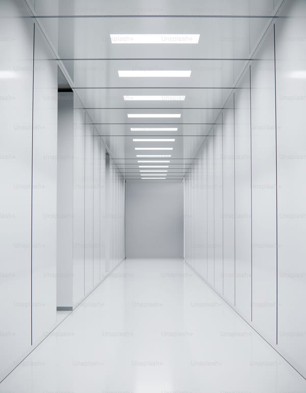 Long architectural passage with overhead ceiling lights, depicting depth and the long view that defines advisory work
