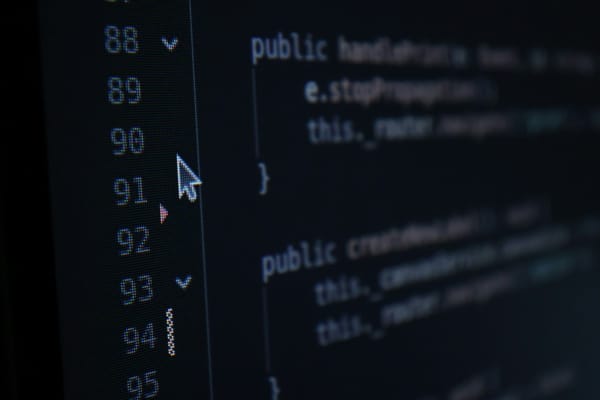 Computer code with line numbers on a dark editor screen, representing the Build stage where engineering ships